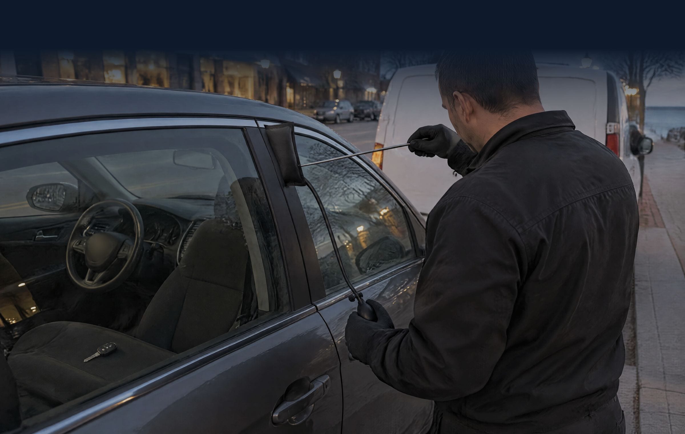Technician opening a locked car door with a wedge, air bag and reach rod at dusk